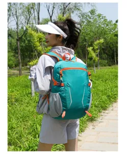 Outdoor lifestyle detail shot of a green travel backpack worn by a model in nature park.