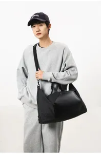 Vue détaillée d'un grand sac de voyage en toile noire avec des détails en cuir portés.