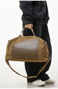 Vue détaillée d'un grand sac de voyage en toile marron porté par le mannequin en studio.