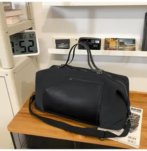 Vue détaillée du grand sac de voyage décontracté, toile noire avec poche en cuir.