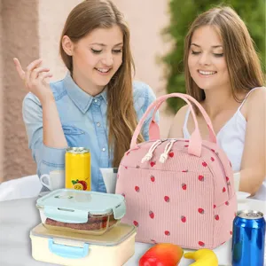 Pink corduroy lunch bag with strawberry pattern shown in an outdoor picnic lifestyle scene