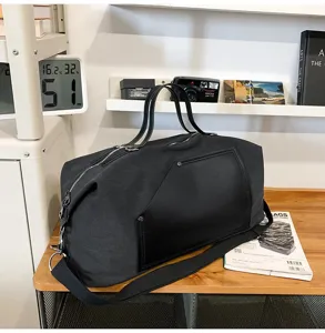 Grand sac de voyage en toile avec empiècement en cuir noir, idéal pour loisirs et déplacements.
