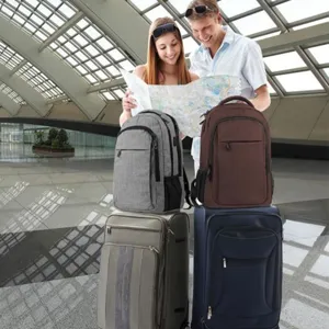 Mochilas de negocios grises y marrones sobre maletas en un entorno de terminal