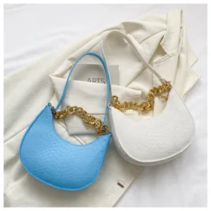 Detalle de bolsos hobo vintage con textura de cocodrilo y correas de cadena dorada