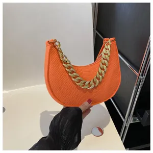 Primer plano detallado de bolso hobo de fieltro naranja con textura de serpiente y cadena