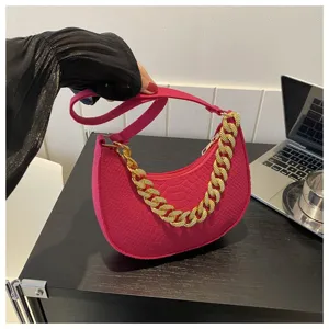 Vista de detalle del bolso de fieltro magenta con cadena dorada y textura de coco.