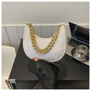 Primer plano detallado de un bolso hobo de fieltro blanco con asa de cadena dorada elegante
