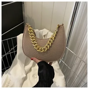 Primer plano de bolso hobo de fieltro beige con textura en relieve y cadena dorada