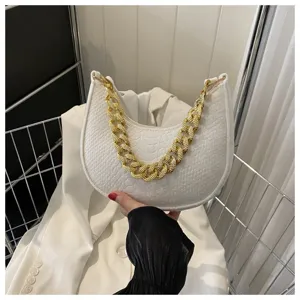 Primer plano del bolso hobo de fieltro blanco con asa de cadena dorada y acabado texturizado