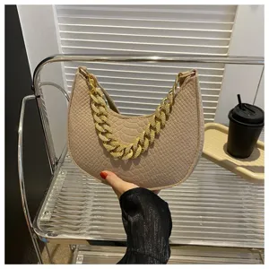 Detalle de bolso hobo de fieltro beige con cadena dorada llamativa y acabado texturizado