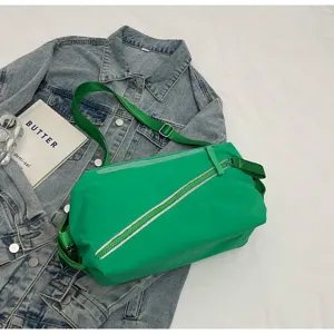 Primo piano dettagliato di una borsa a tracolla verde brillante con zip diagonale.