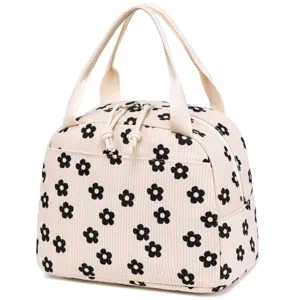 Detailed view of cream corduroy insulated lunch bag with black floral daisy pattern
