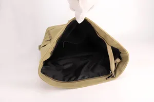 Detailed view of the black interior lining and compartment of the khaki canvas backpack