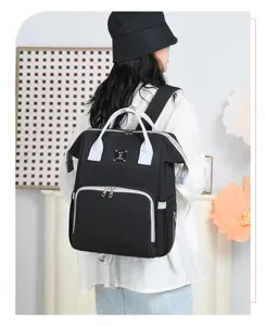 Back view of a black large capacity diaper bag backpack worn by a model in a studio