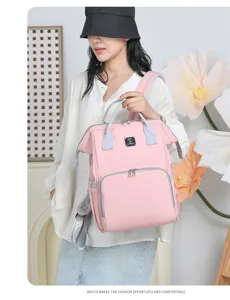 Asian model carries a pink large-capacity diaper backpack for maternal and baby outings