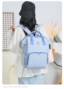 Stylish light blue diaper backpack with large capacity shown on a model for travel