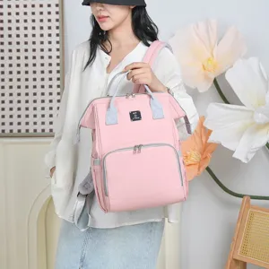 Stylish pink diaper bag showcased by an Asian model in a bright, modern interior setting.