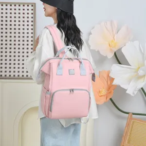 Detail view of a stylish pink diaper backpack worn by a model in a lifestyle setting.