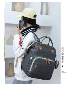 Modell trägt einen grauen Multifunktions-Wickelrucksack mit großem Fassungsvermögen und Fächern