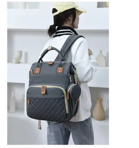 Seitenansicht grauer gesteppter Wickelrucksack von Modell in minimalistischem Raum