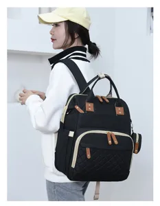 Detailansicht der großen schwarzen Wickeltasche im Rucksack-Stil, von Model getragen