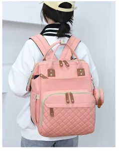 Stylischer rosa Wickelrucksack mit Steppdetails, getragen von einem Model in Alltagsumgebung