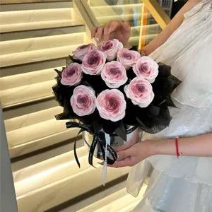 Exquisito ramo de rosas artificiales degradadas en caja de regalo redonda para San Valentín.
