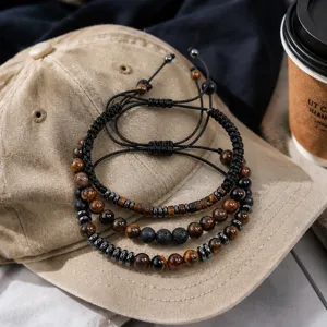 Gros plan d'un ensemble de bracelets perlés 8mm pour hommes avec œil de tigre et pierre lave.