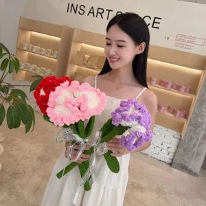 Asian model holding large handmade knit carnation flowers in a warm lifestyle studio