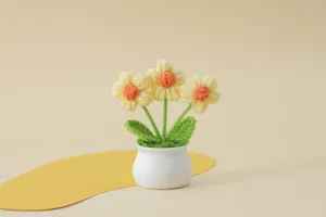 Handgefertigte gehäkelte Sonnenblumen im Topf Detail, süße Wollstrickblume Heimdeko Nahaufnahme.