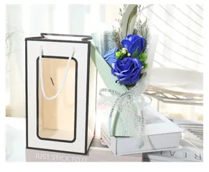 Detailed close-up view of a romantic blue soap flower bouquet displayed with a white gift bag.