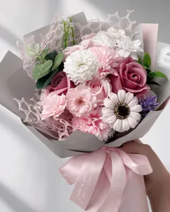 Close-up of elegant pink rose and carnation artificial flower bouquet with ribbon