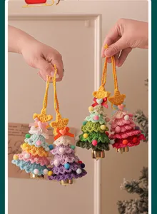 Handmade crochet Christmas tree ornament with colorful pom-poms, bows, and bells for holiday decor.