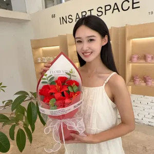 Smiling Asian model holding a red soap flower bouquet with roses and lilies for Mother's Day gift