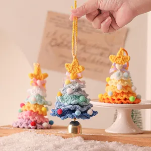 Handmade crochet Christmas tree hanging ornament with bell and colorful balls for holiday decor.
