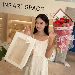 Asian model holding a red soap flower bouquet and white gift bag for Mother's Day