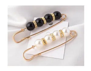 Close-up of elegant pearl safety pin brooches in black and white with rhinestones