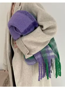 Close-up detail of a soft purple and green plaid mohair scarf with thick tassels