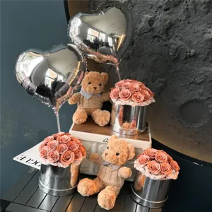 Vue détaillée de mignons ours en peluche et de boîtes de roses argentées élégantes.