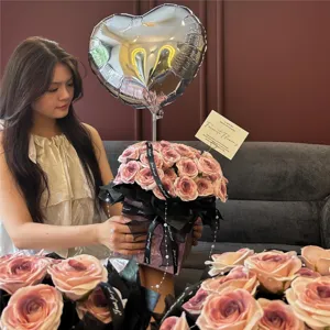 Vista detallada del ramo de rosas de San Valentin con globo de corazon en interiores.