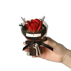 Close up view of red soap rose pocket bouquet with elegant black wrapping and bow ribbon gift.