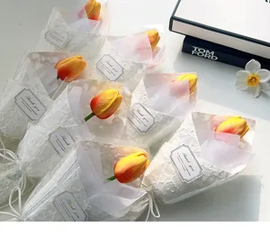 Vista di dettaglio ravvicinato di un bouquet di tulipani artificiali in carta bianca con etichetta.