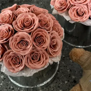 Vue detaillee d'un arrangement de roses roses elegantes dans une boite cadeau avec peluche.