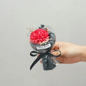 Detail view of a pocket preserved flower bouquet with red carnations and black wrapping ribbon.