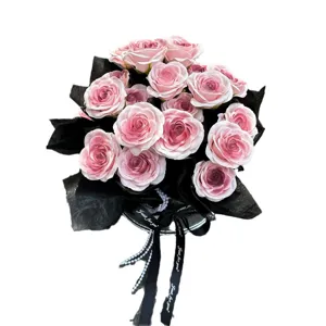 Ramo de rosas artificiales rosas con papel de envolver negro para regalo de San Valentín.
