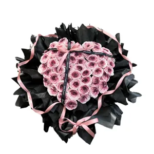 Herzform Seifenrosen Blumenstrauß mit schwarzem Papier und rosa Schleife für Valentinstag.