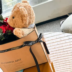 Bouquet de fleurs avec peluche d'ours et roses rouges dans une jolie boîte cadeau romantique.