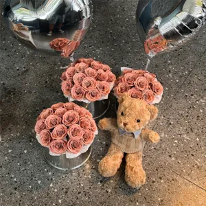 Vue détaillée d'un ours en peluche, d'un bouquet de roses en savon et de ballons cœur pour cadeau.
