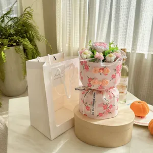 Bouquet de fleurs fait main au crochet dans un emballage rose style qipao avec sac cadeau