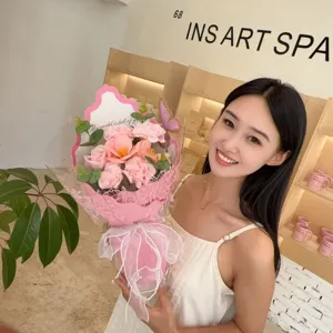 Handheld soap flower bouquet with pink carnations and roses held by an Asian model